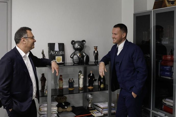 Deux avocats accoudés à une étagère.