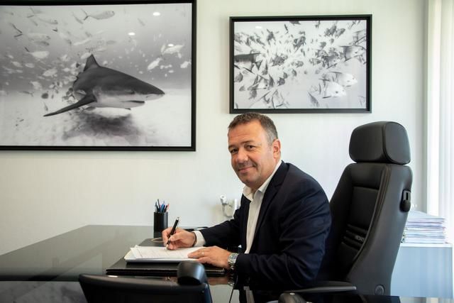 Avocat assis à un bureau où il y a une photo de requin.
