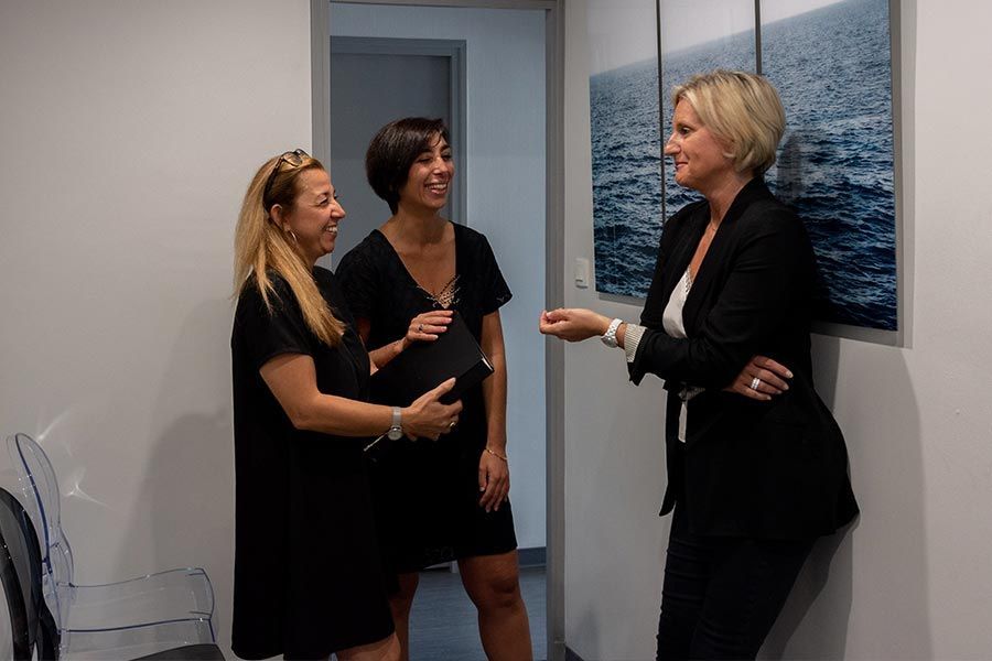 Trois collaboratrices qui discutent à l'intérieur du cabinet La Balme.