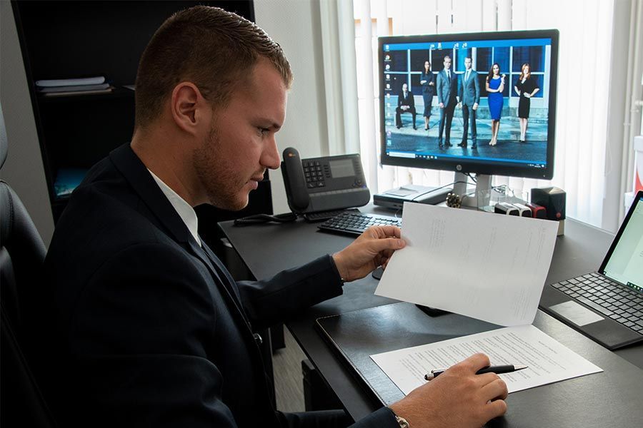 Maître Louis-Marie La Balme qui lit un document tout en prenant des notes.