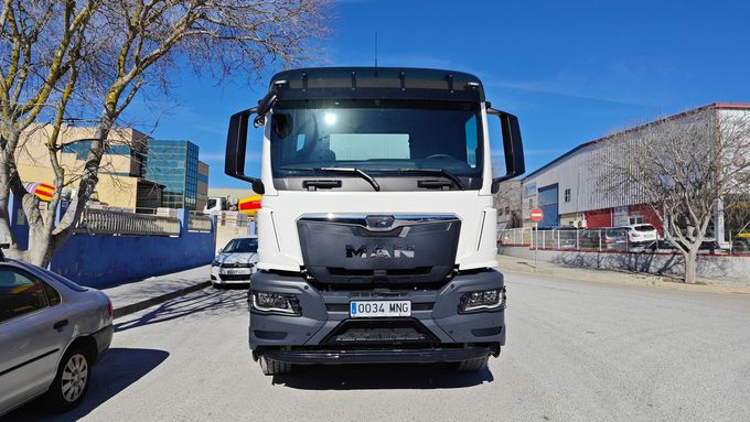 Un camión blanco está estacionado en un estacionamiento al lado de un automóvil.
