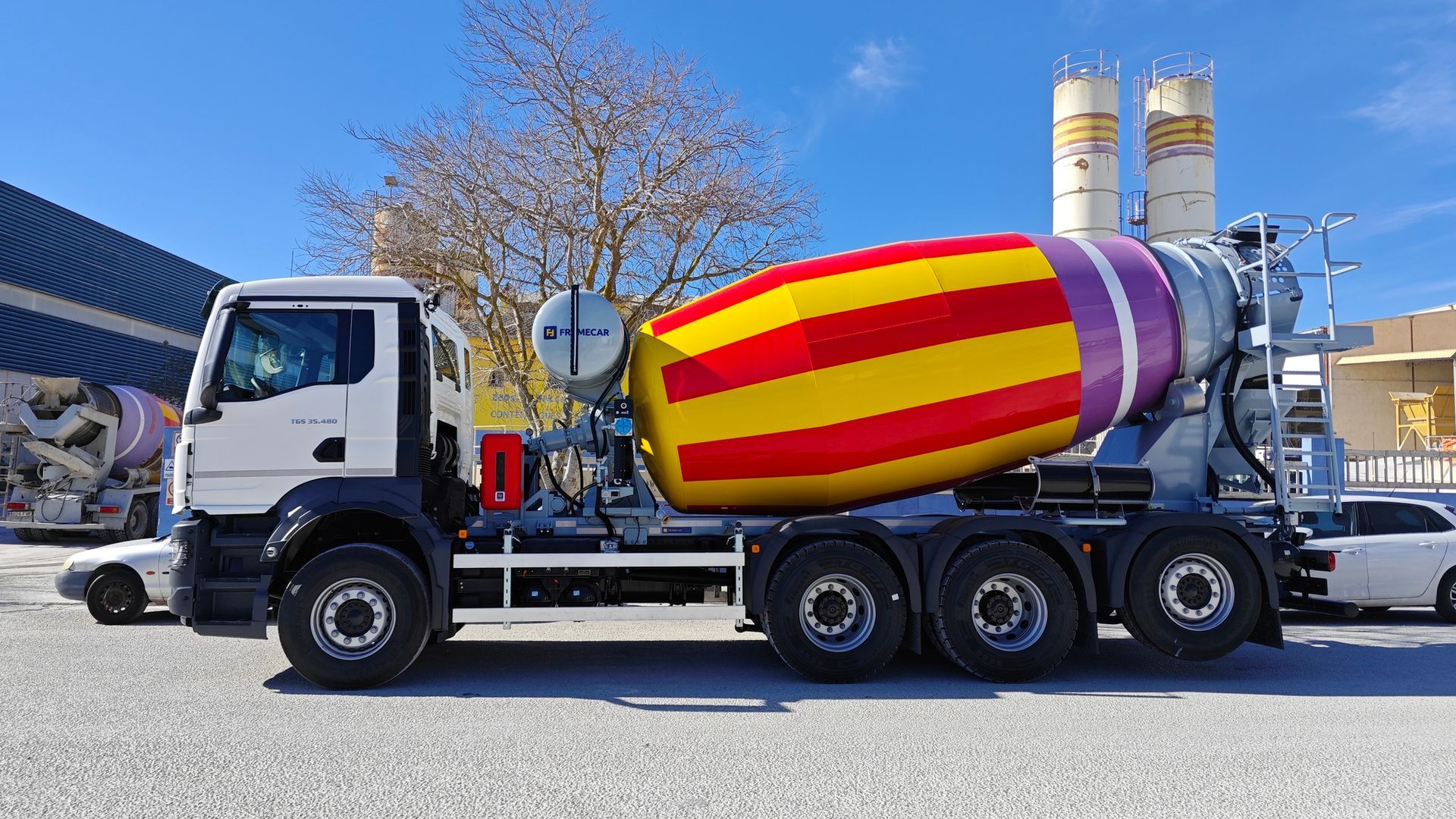 Un camión hormigonera está estacionado en un lote de grava.
