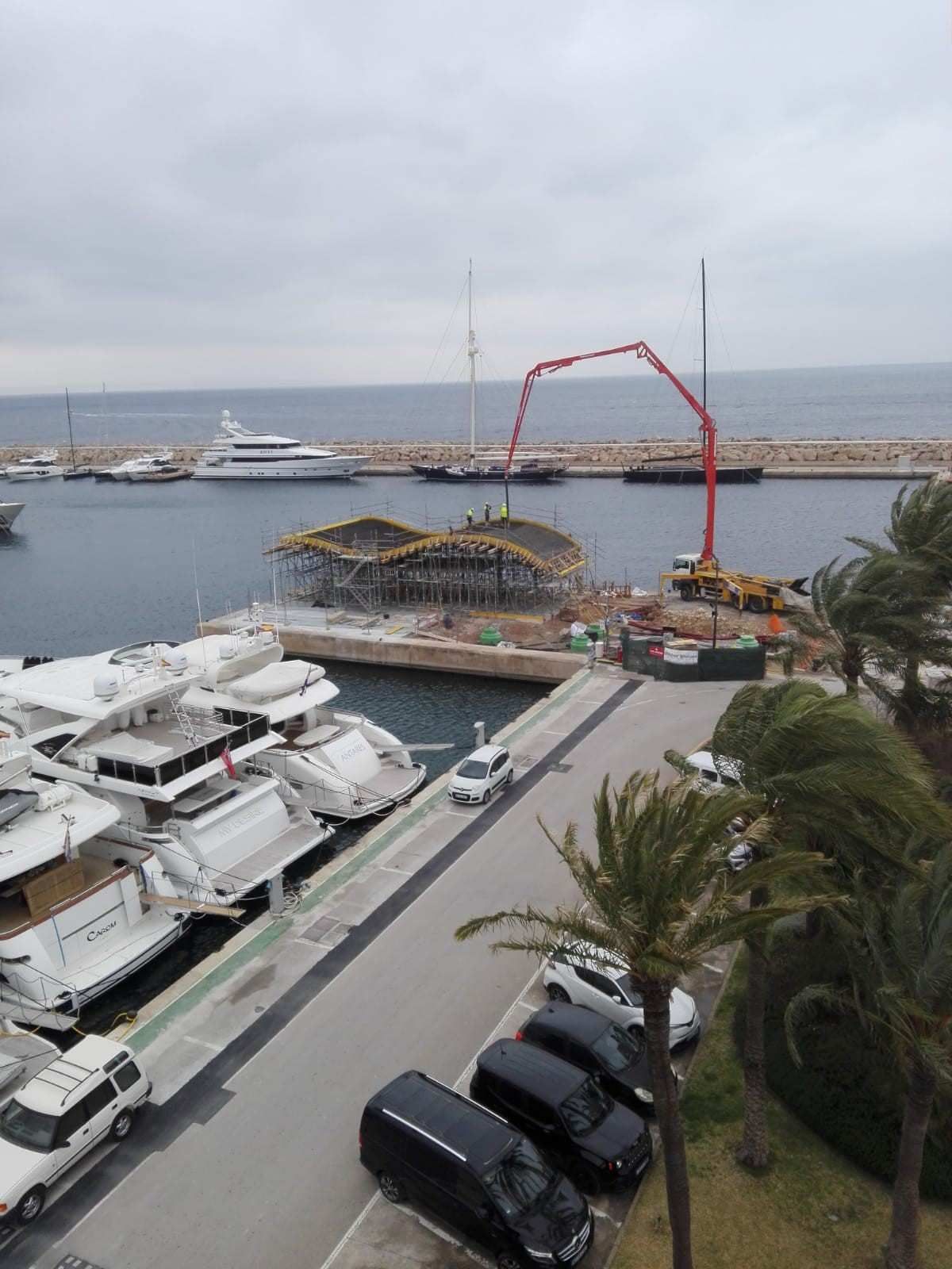 Una vista aérea de un puerto deportivo con barcos y coches estacionados.