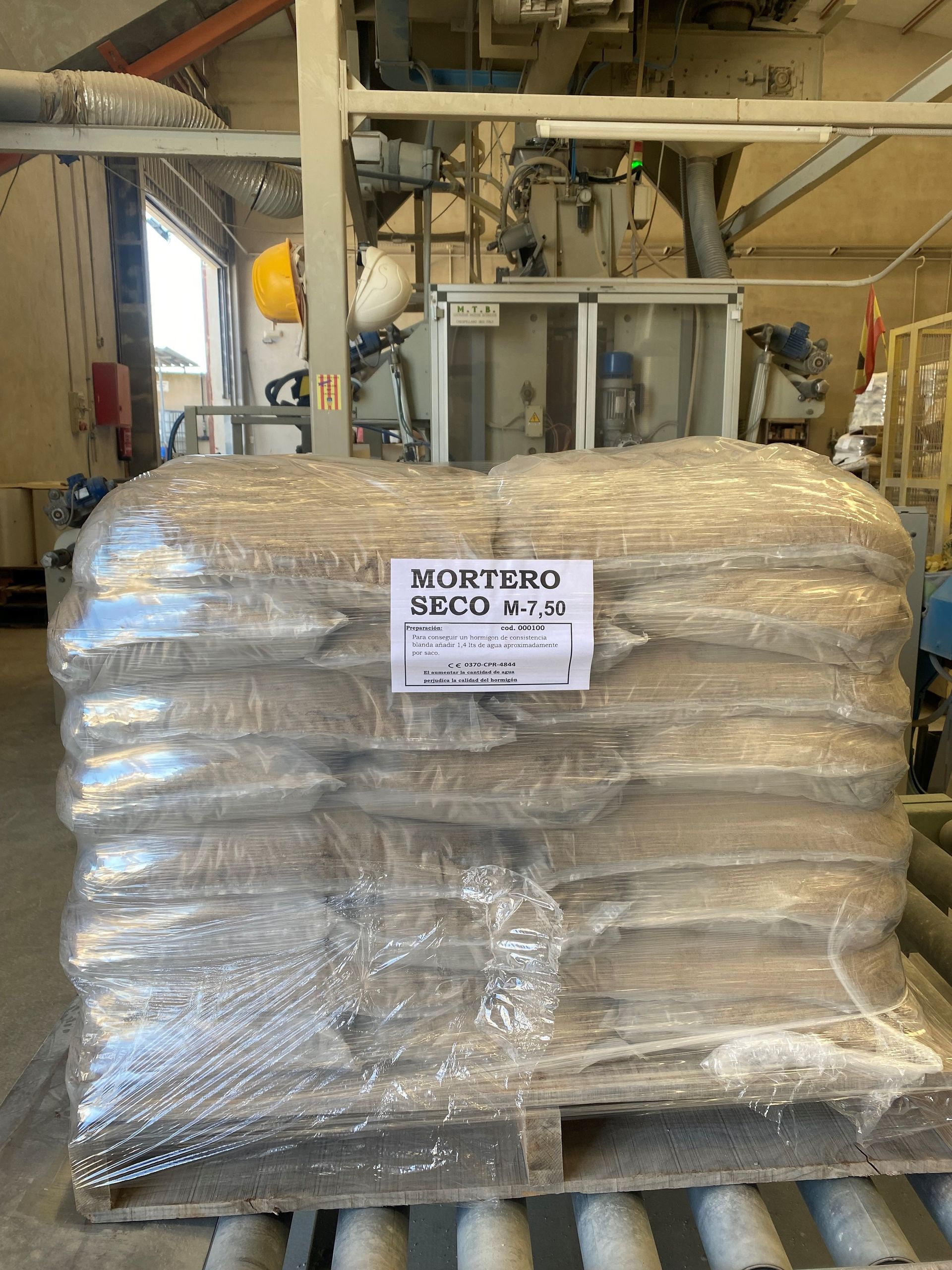 Una gran bolsa de grano está envuelta en plástico y colocada sobre una paleta de madera.