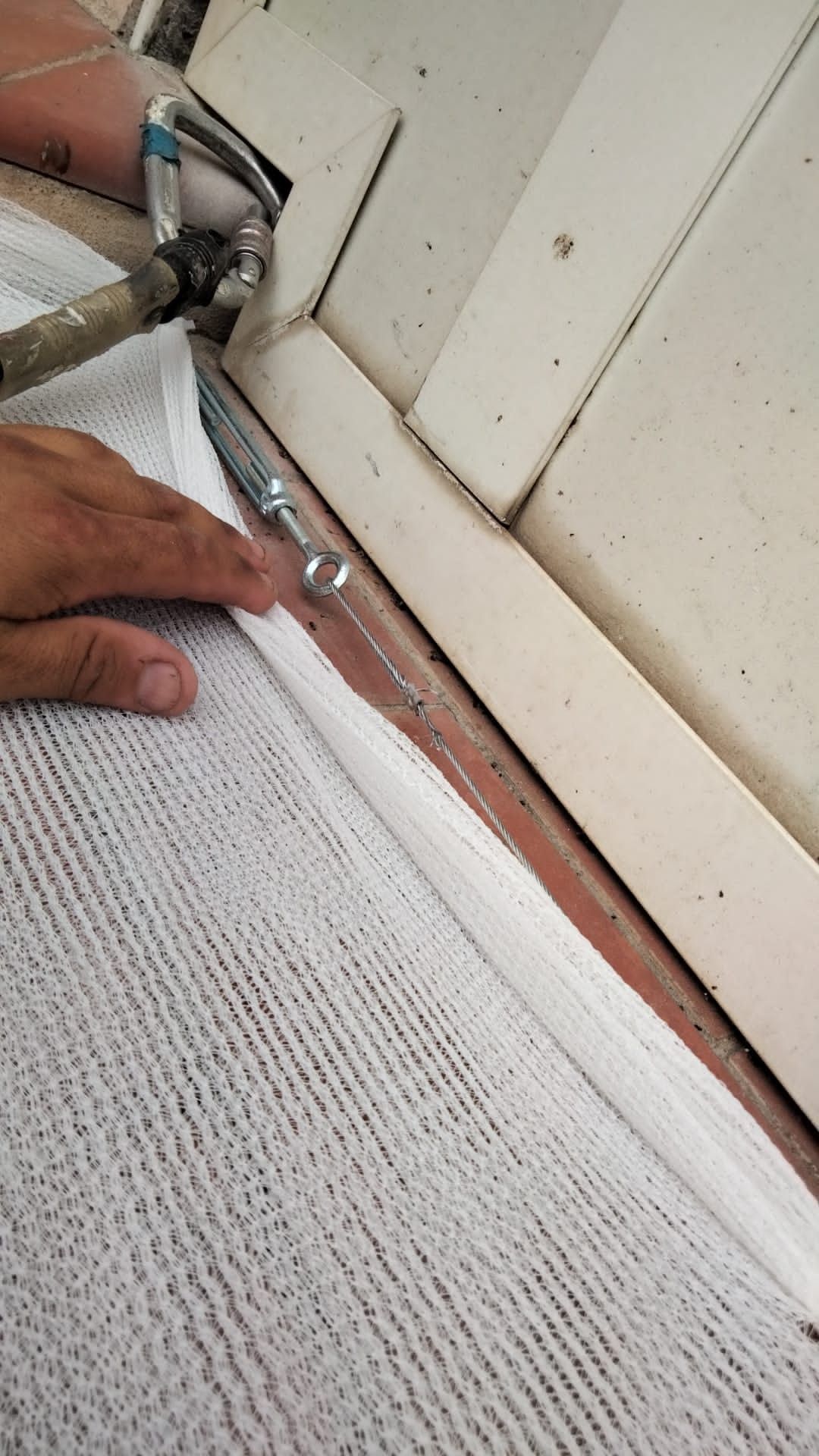 Una persona está cortando un trozo de alfombra con un par de tijeras.