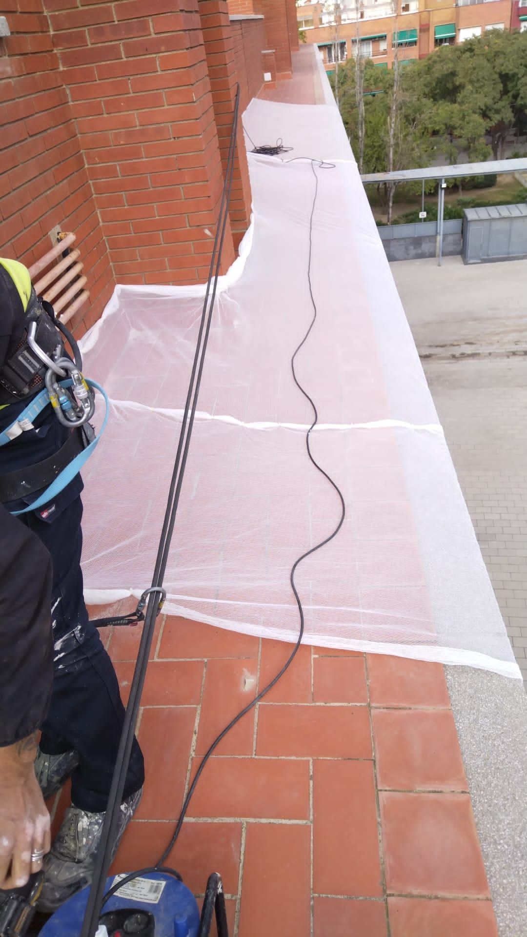 Un hombre está trabajando en un balcón con una aspiradora.