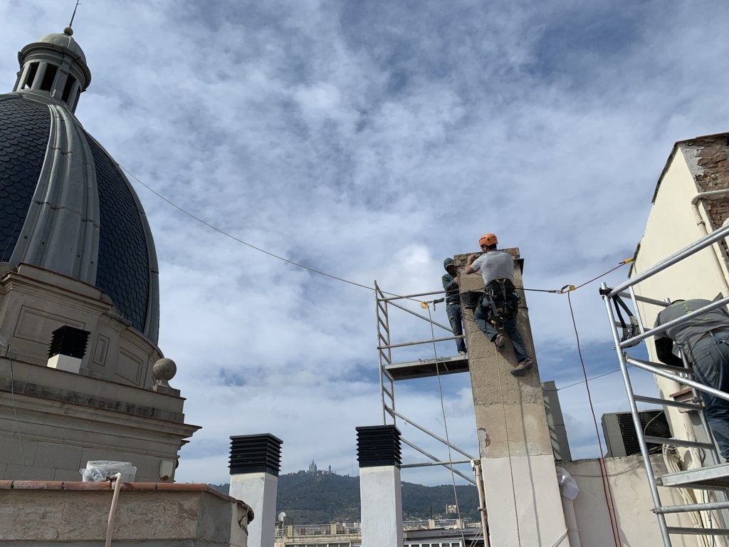 Un grupo de personas está trabajando en un edificio con una cúpula al fondo.