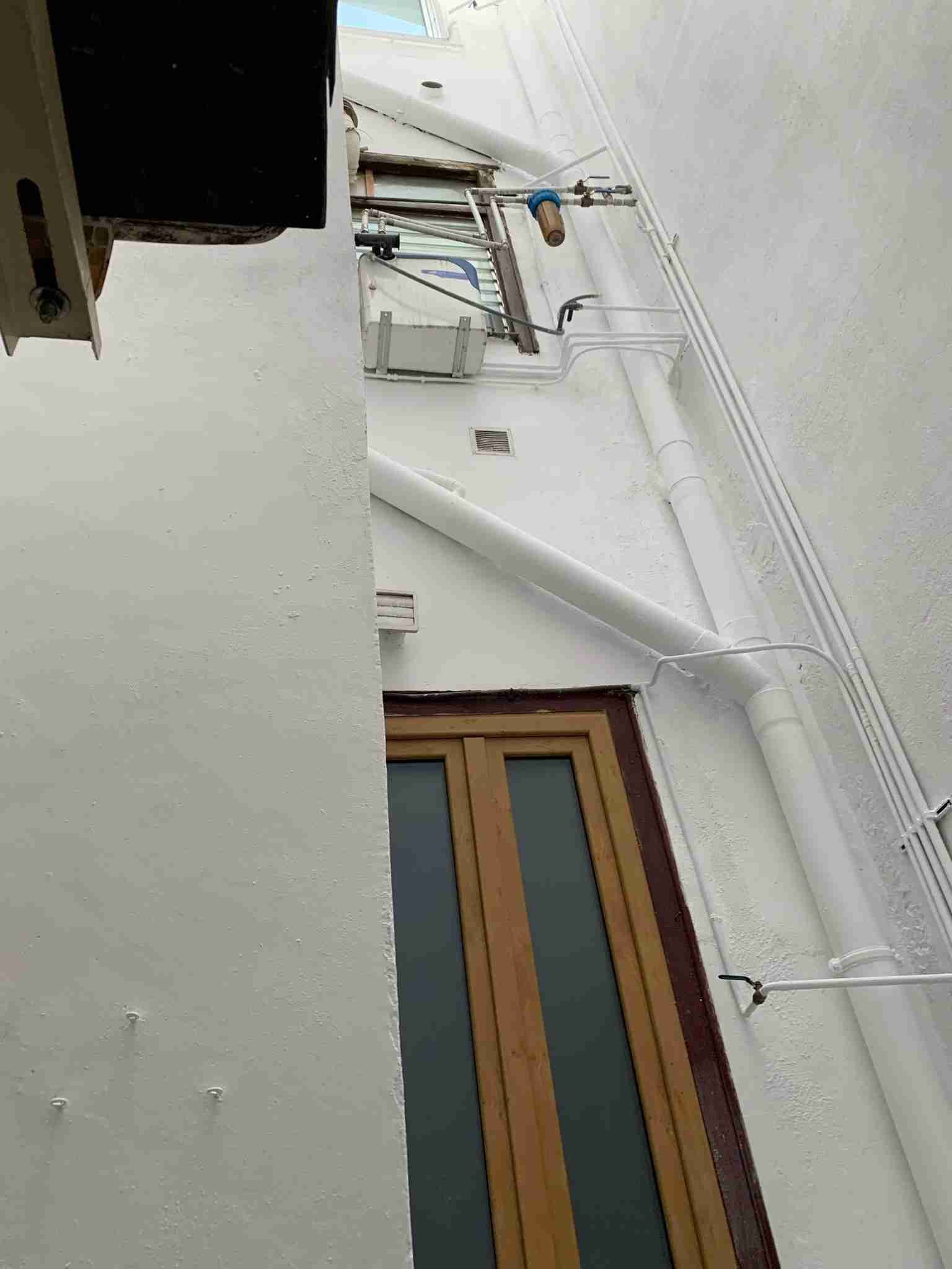 Un edificio blanco con una puerta de madera y una ventana.