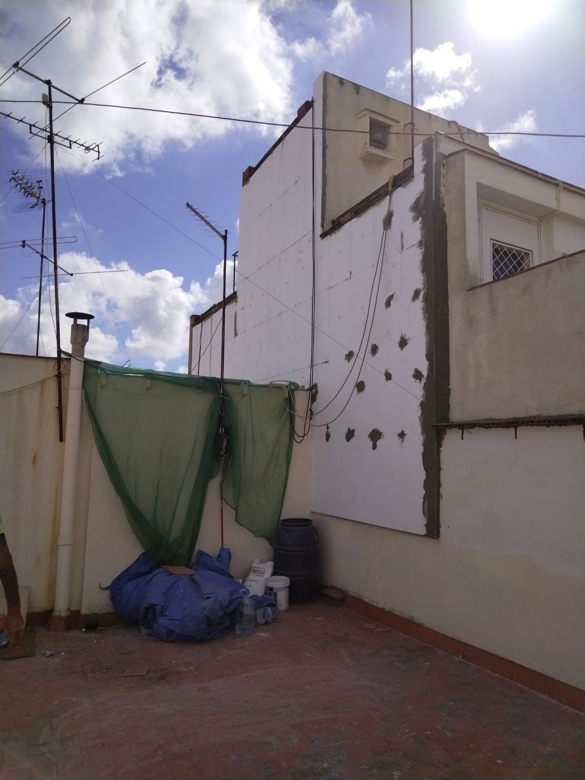 Un edificio con una lona verde al costado.