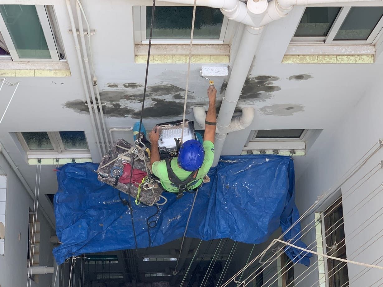 Un hombre está trabajando en el techo de un edificio.