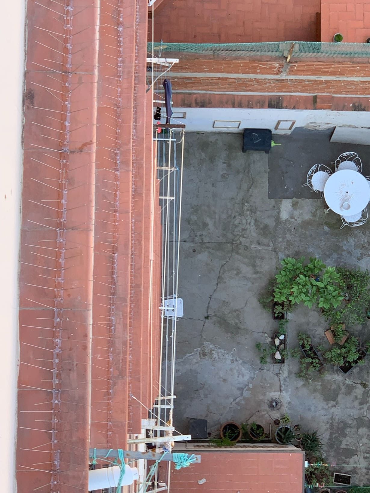 Una vista aérea de un edificio de ladrillo con una mesa y sillas en el patio trasero.