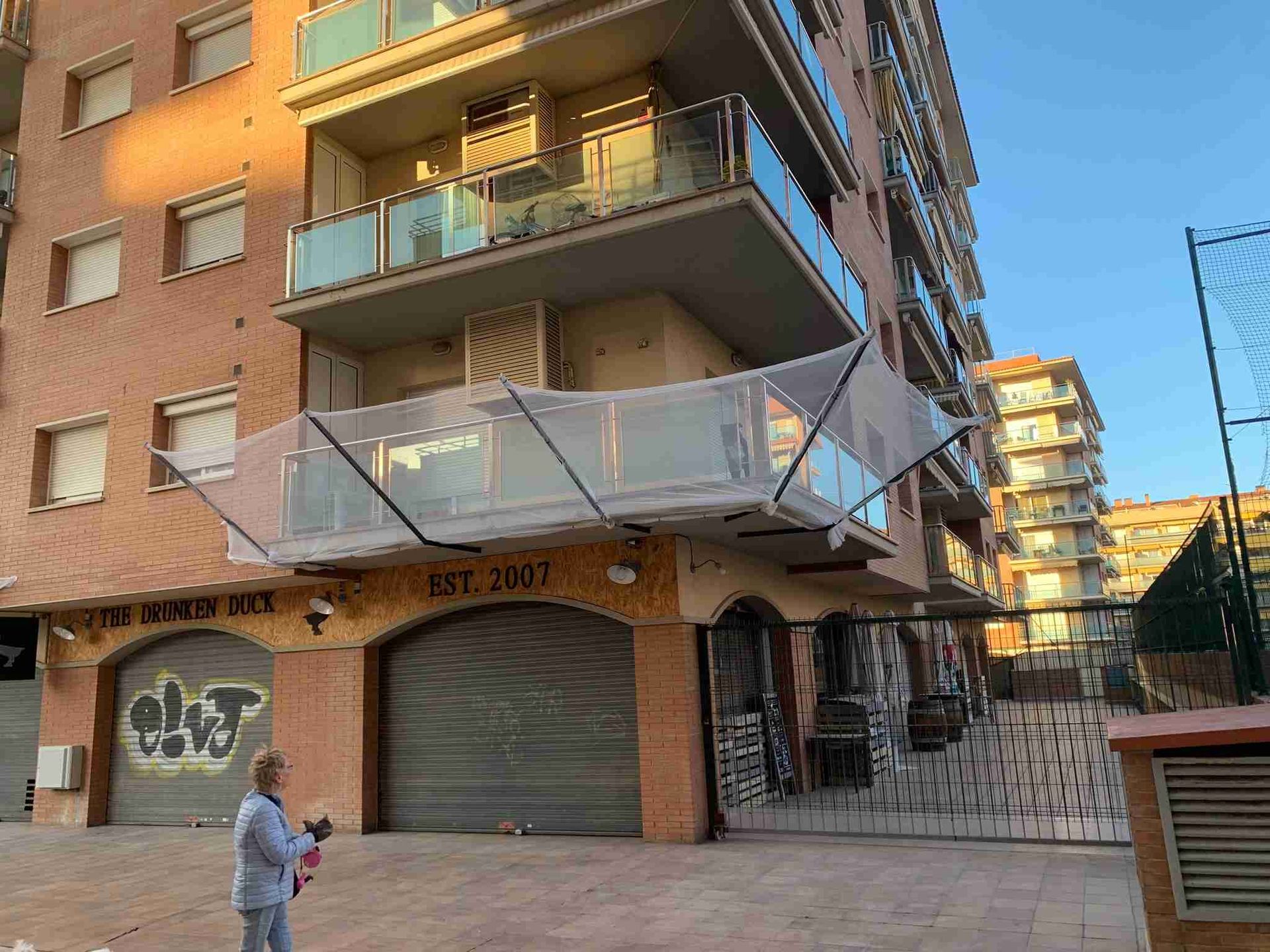 Una mujer está parada frente a un edificio de ladrillos.
