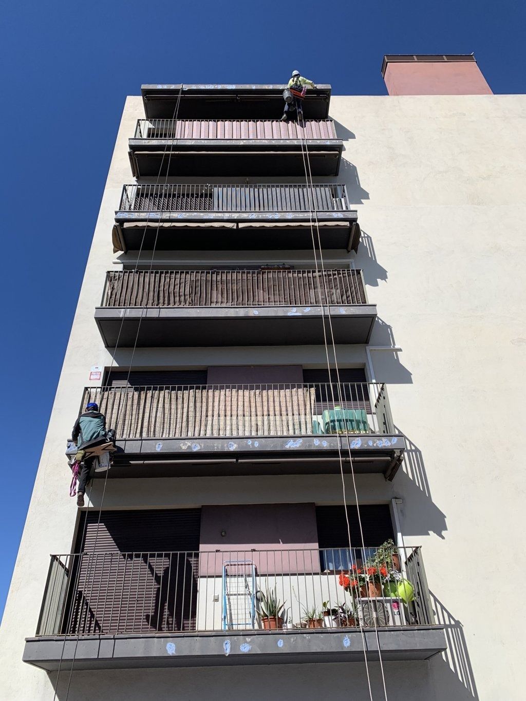 Un edificio con muchos balcones y un cielo azul al fondo.