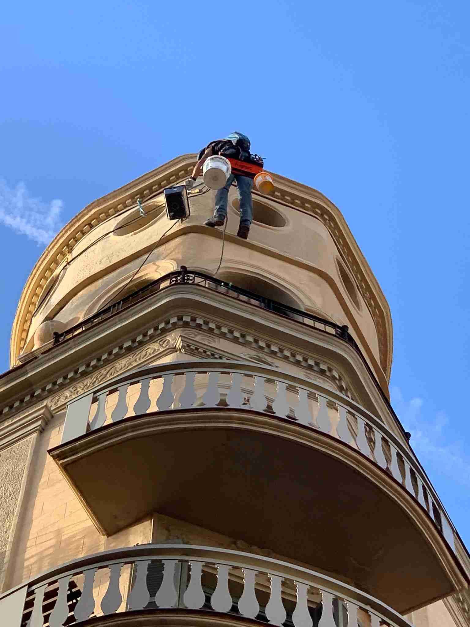 Un hombre está subiendo por el costado de un edificio.