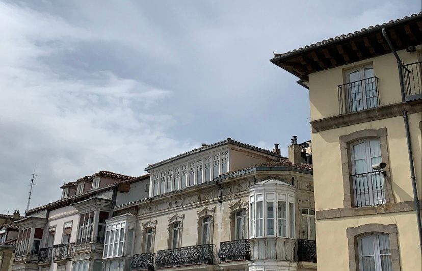 Una fila de banderas ondean frente a un edificio.