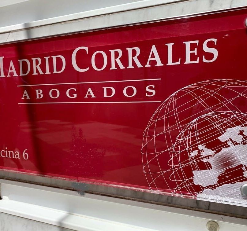 A red sign that says madrid corrales abogados