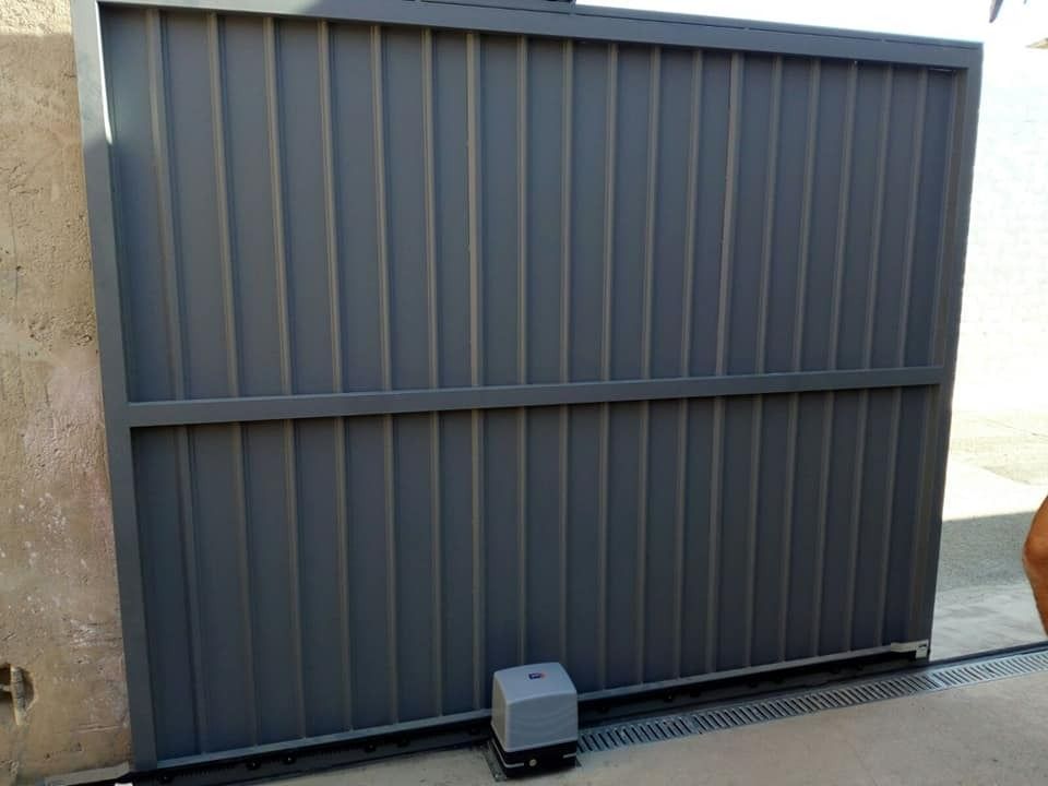 Una puerta corrediza con un motor acoplado está abierta.