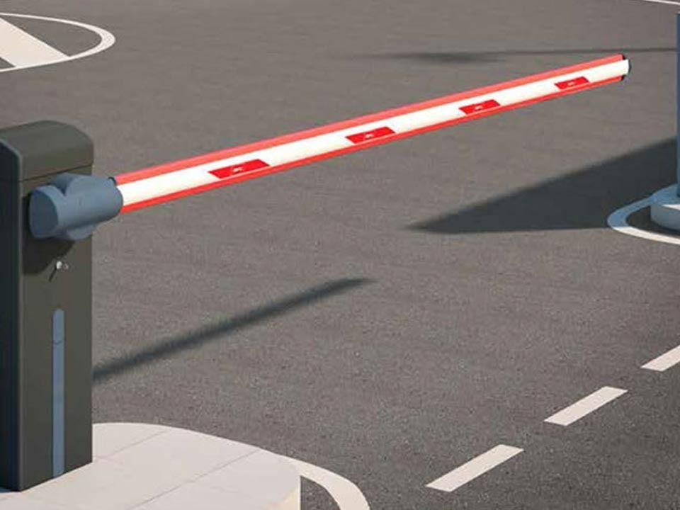 Una barrera roja y blanca está en un estacionamiento
