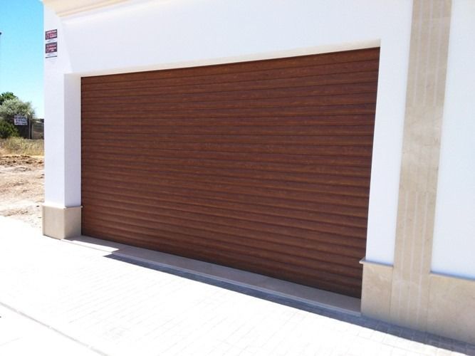 Un edificio blanco con una puerta de garaje marrón