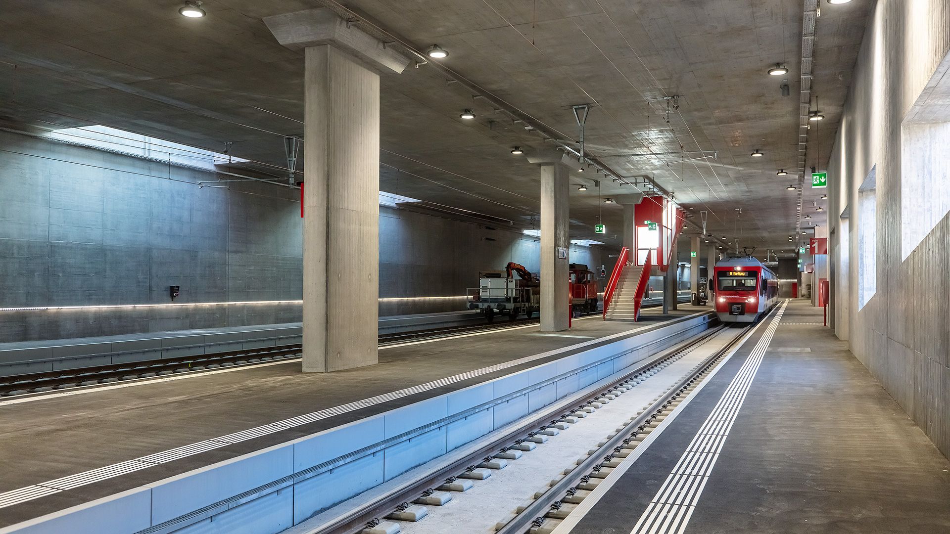 Une gare avec une voiture garée sur les voies.
