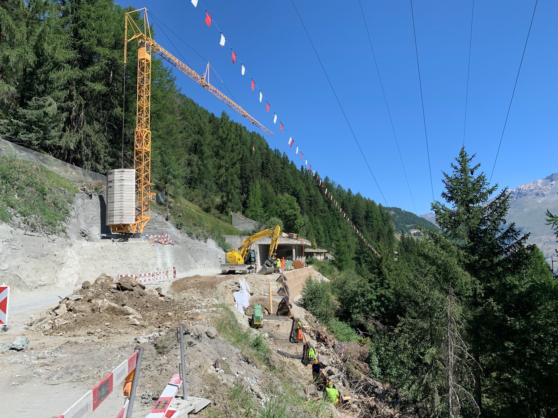 Un chantier de construction dans les montagnes avec une grue en arrière-plan
