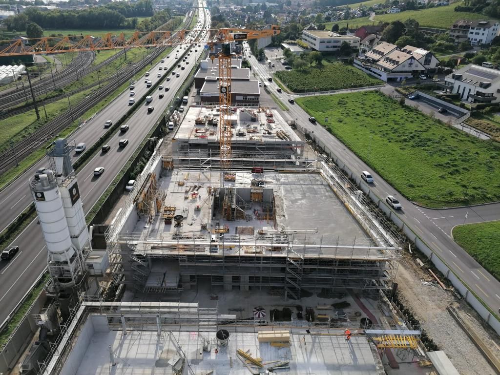 Une vue aérienne d'un chantier de construction avec une autoroute en arrière-plan
