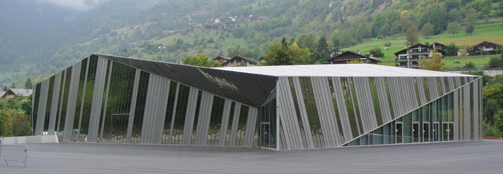 Un grand bâtiment avec beaucoup de fenêtres et une montagne en arrière-plan