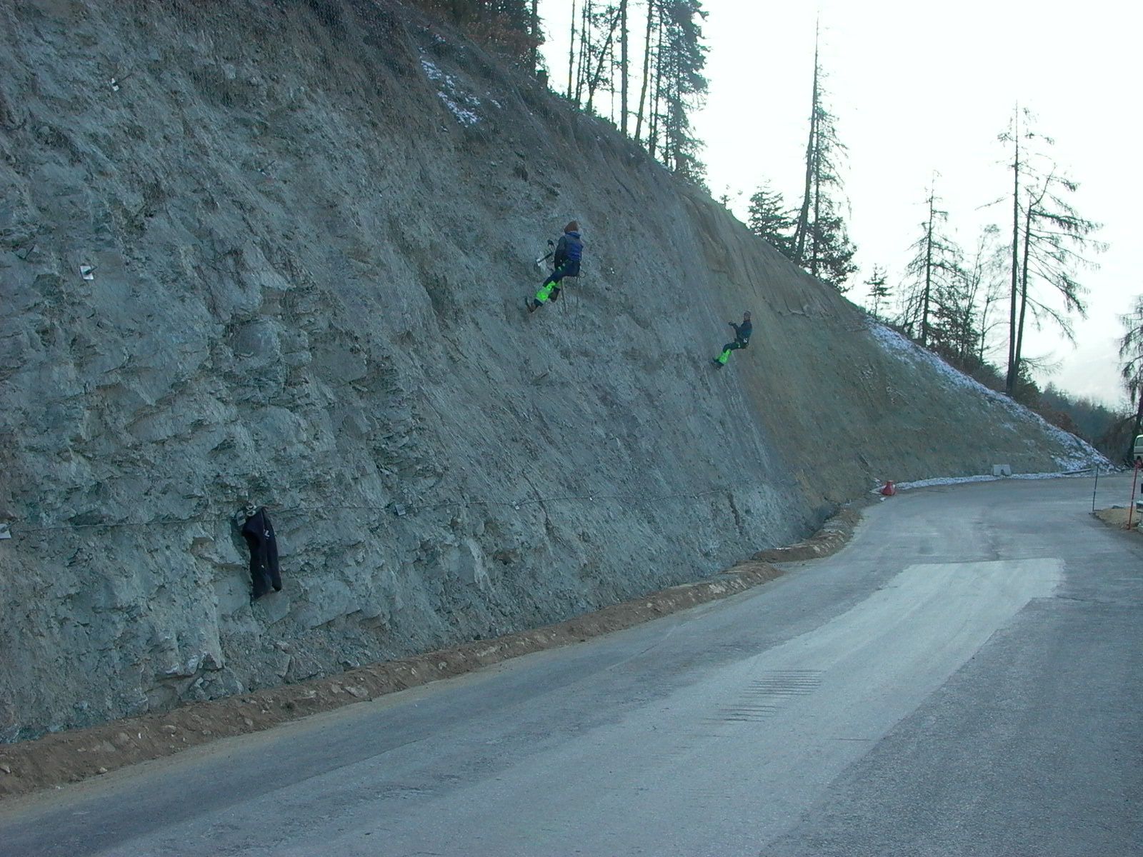 Une route qui monte une colline avec des arbres sur le côté