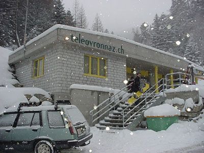 Une voiture est garée devant un bâtiment sur lequel est écrit teleovronnaz.ch