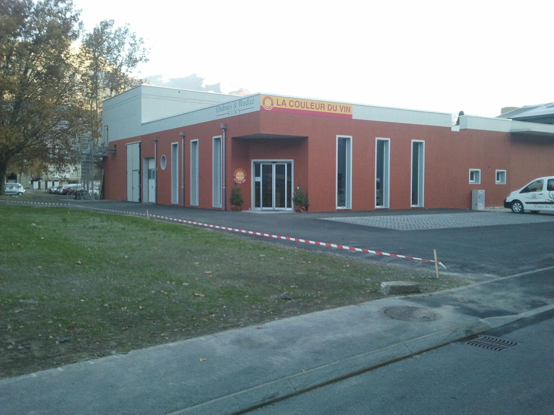 Un grand bâtiment rouge avec une camionnette blanche garée devant