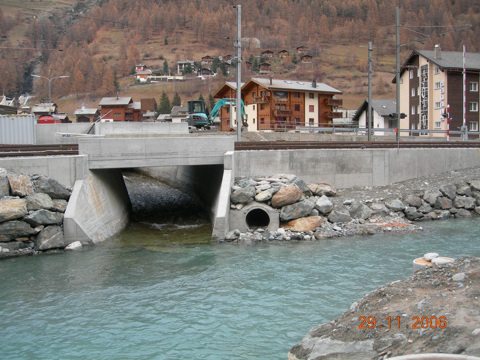 Un pont sur une rivière avec un tracteur en arrière-plan