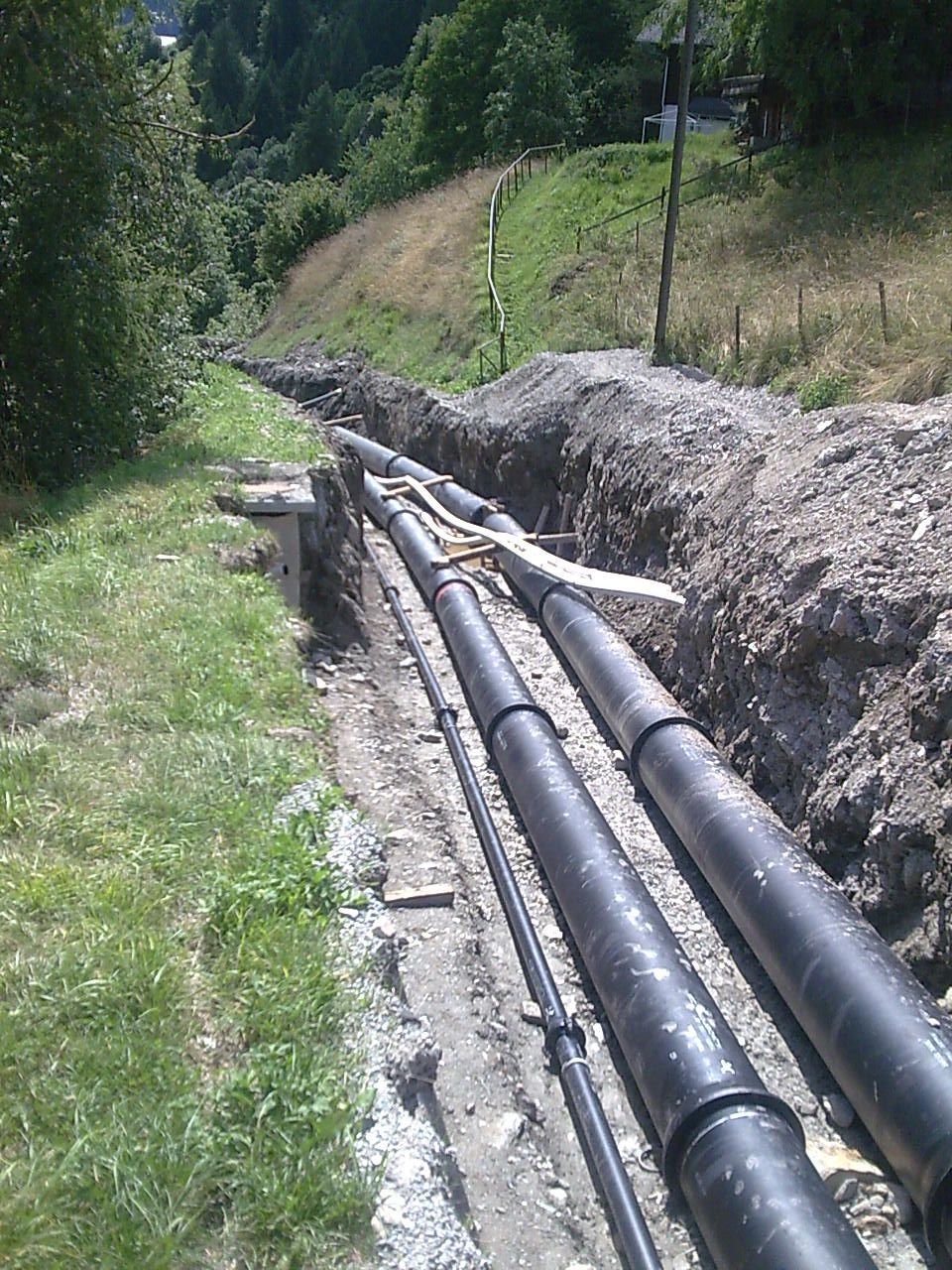 Un tas de tuyaux noirs reposent dans la terre