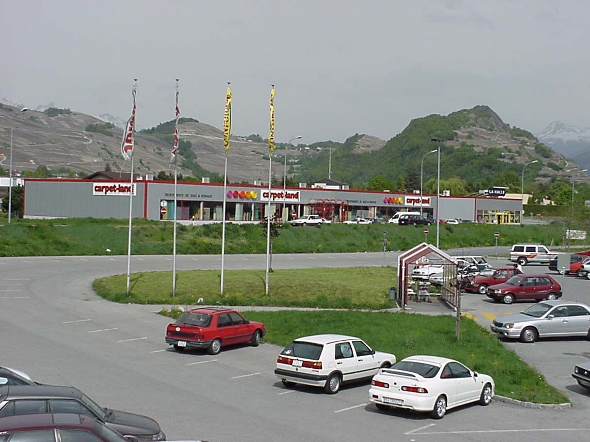 Beaucoup de voitures sont garées devant un bâtiment sur lequel est écrit McDonald's