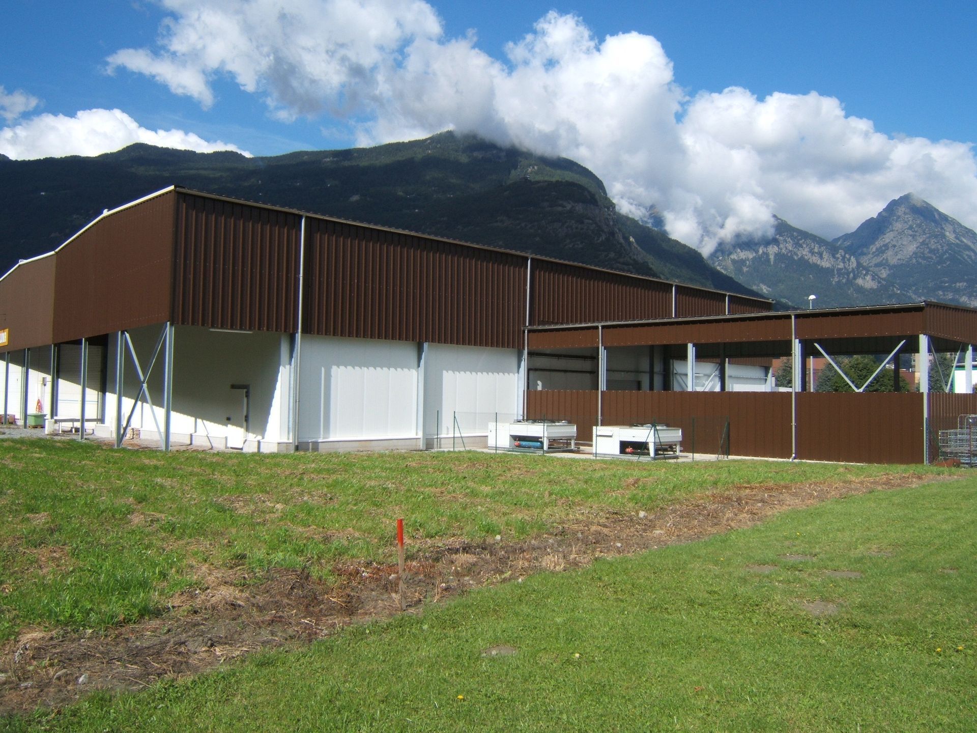 Un grand bâtiment marron avec des montagnes en arrière-plan