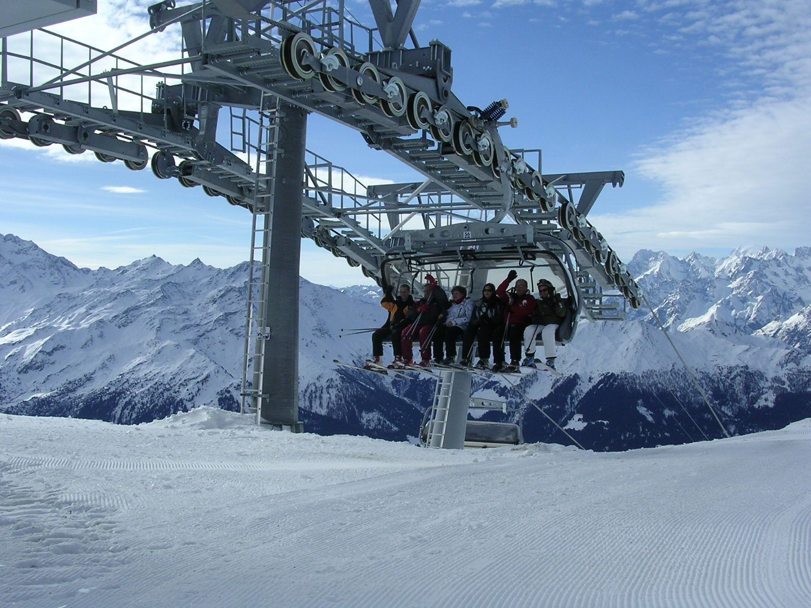 Un groupe de personnes utilise un téléski au sommet d'une montagne enneigée.