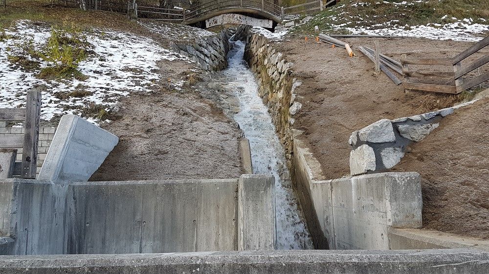 Un jet d'eau coule à travers un mur de béton.
