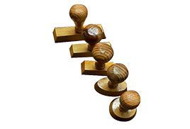 Cinco carimbos de madeira com cabos arredondados.