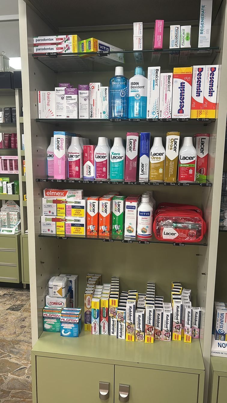 Estante de tienda con artículos de aseo y frascos de medicamentos variados, como pasta de dientes, pomadas y jabón.