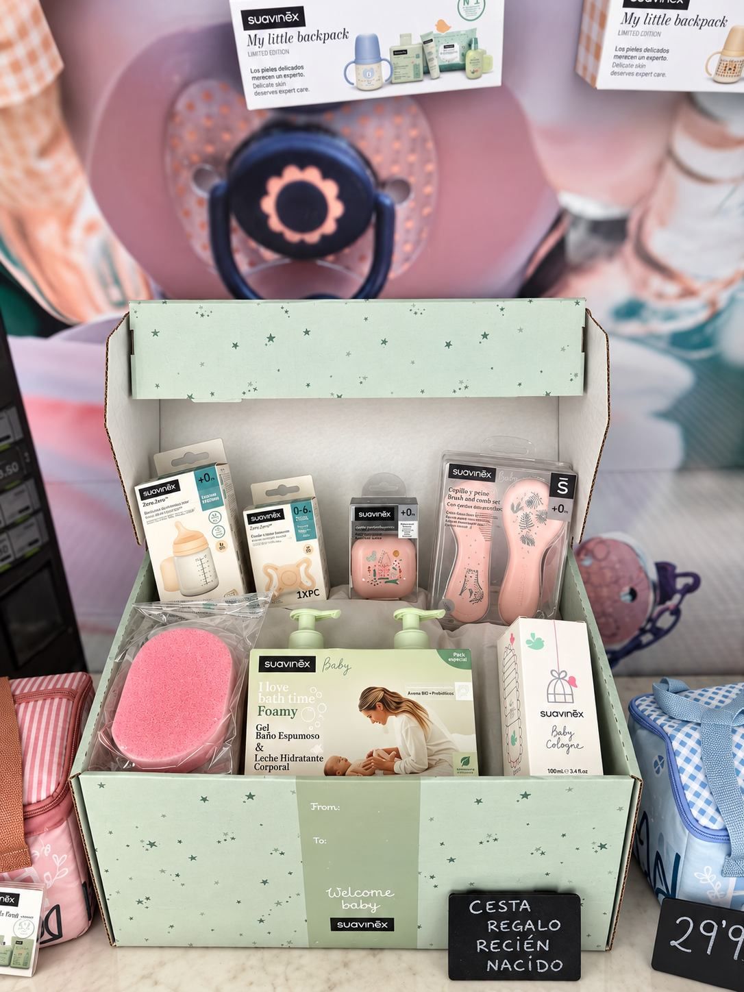 Estuche de regalo con productos de spa rosas en una estantería de tienda, con envases en tonos pastel y una etiqueta de precio.