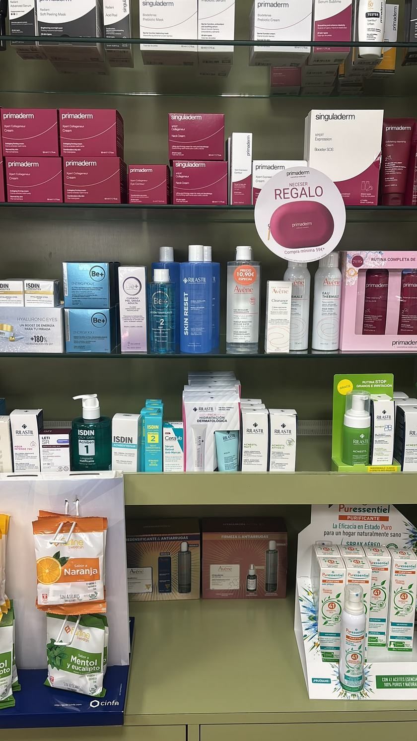 Estante de tienda repleta de productos variados para el cuidado de la piel y cosméticos en cajas y frascos