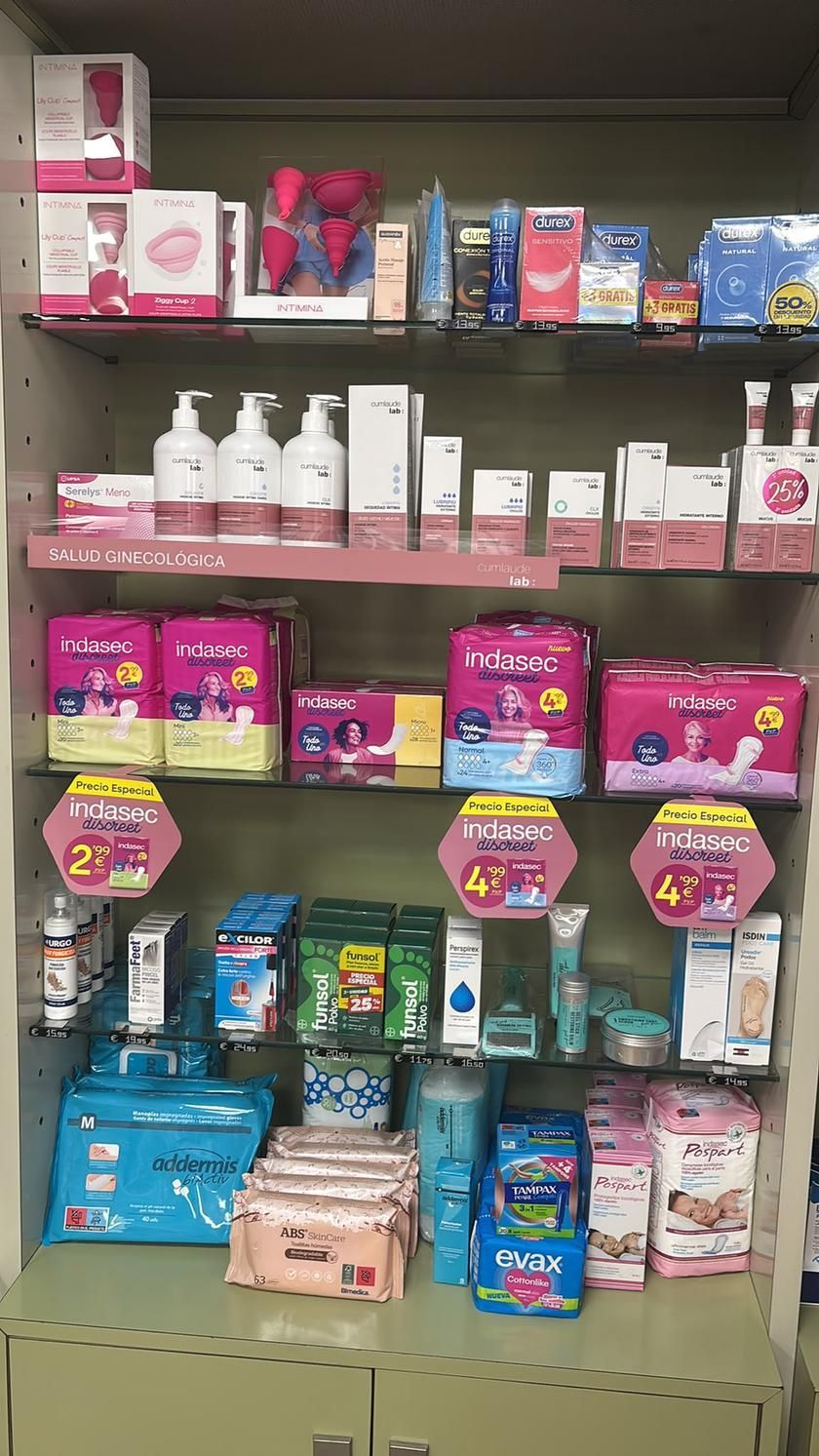 Estante de tienda con diversos productos de cuidado personal envasados en rosa, azul y blanco, y botellas