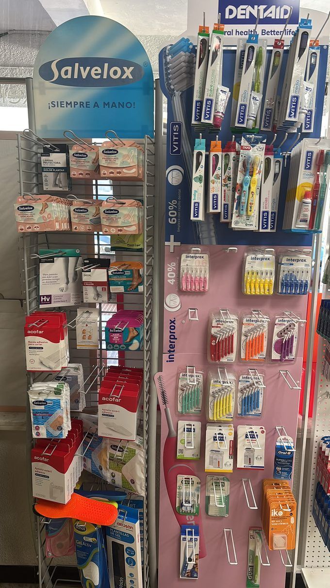 Expositor de productos de higiene dental en paneles perforados azules y rosas