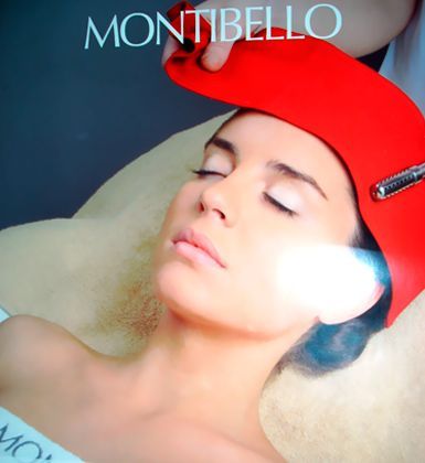 Una mujer que lleva un sombrero rojo está recibiendo un tratamiento de Montibello.