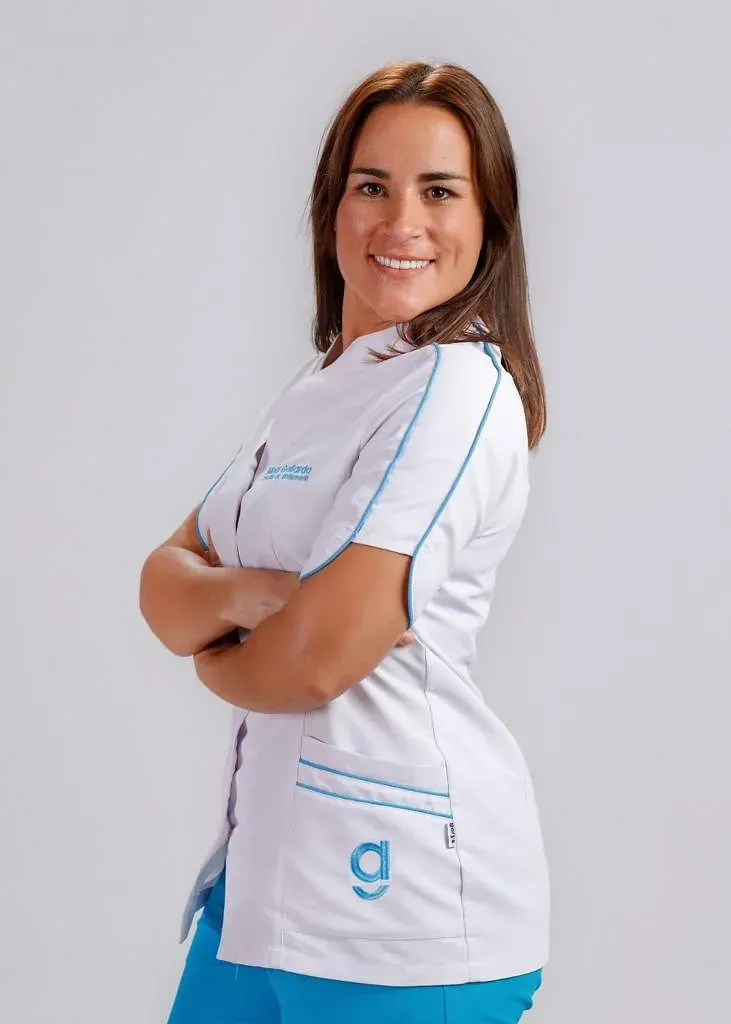 Una mujer que lleva una bata blanca con la letra g.