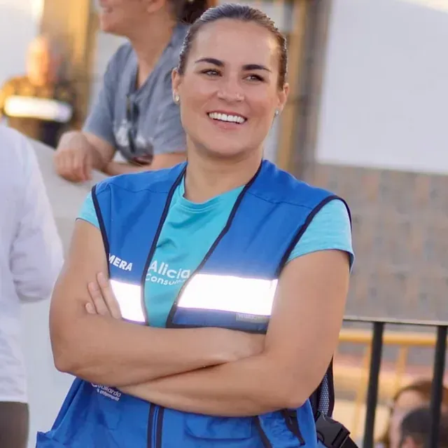 Una mujer que lleva un chaleco azul con la palabra policía.