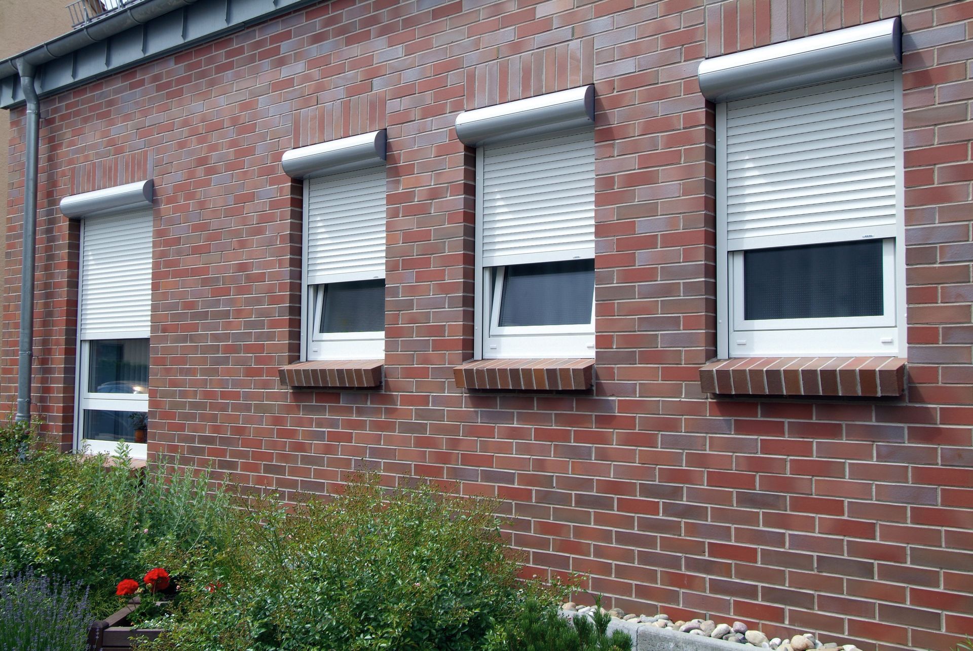 Façade maison en brique avec volet roulant extérieur blanc