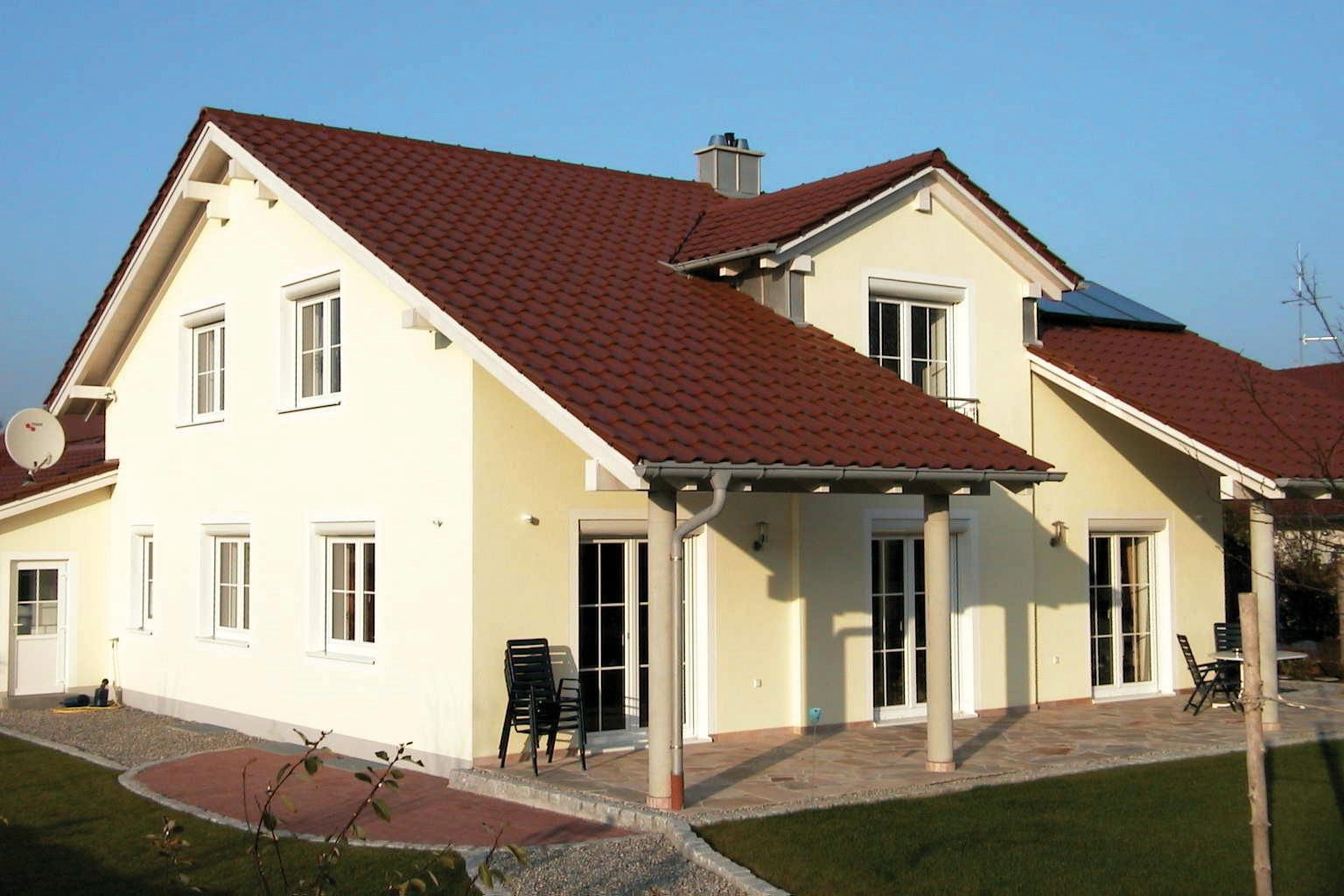 maison avec façade beige et toiture en tuile rouge et volet roulant sur menuiserie