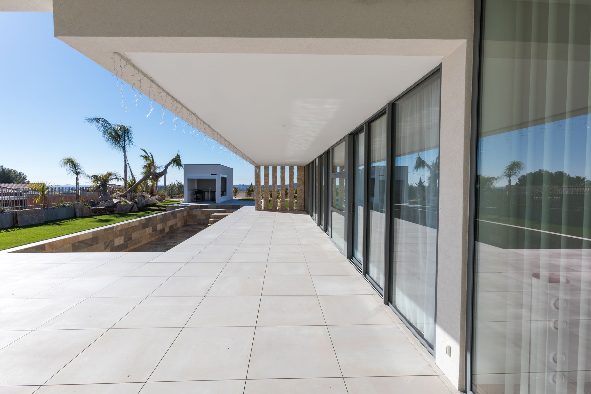 Baie vitrée en aluminium donnant sur une grande terrasse en marbre