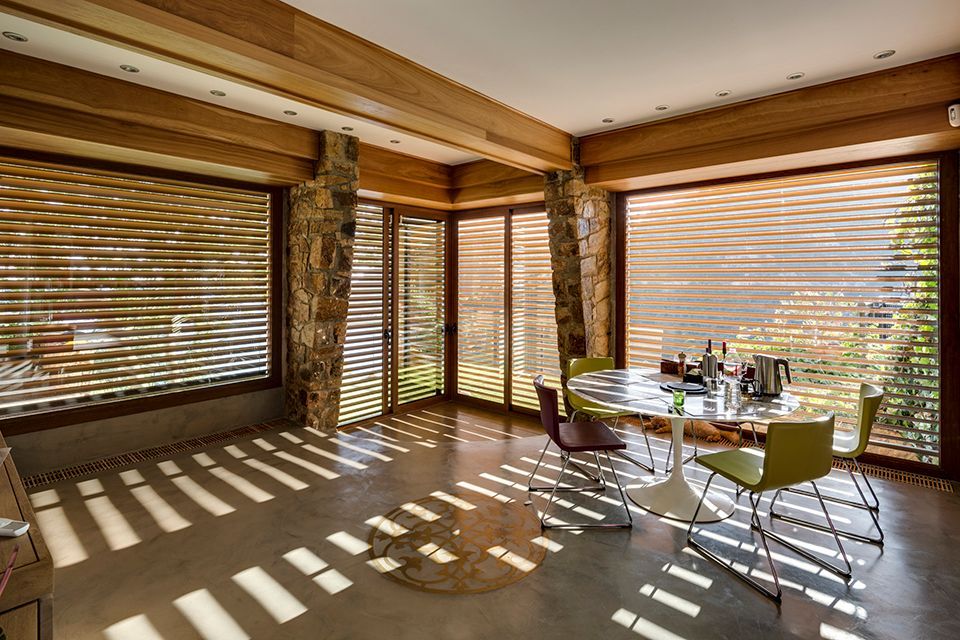 Vue intérieure d'une maison avec poutre en bois et brise-soleil en bois