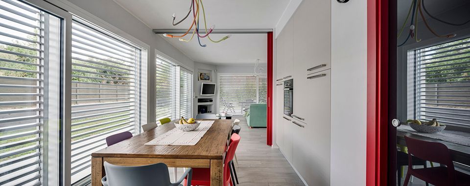 Intérieur d'une maison avec grande baie vitrée et brise-soleil blanc devant